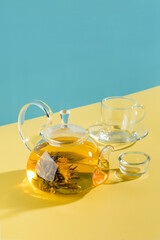 Green tea. Blooming flower in glass teapot