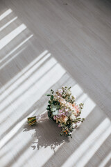 Wedding bouquet of peonies flowers on the floor of the newlyweds