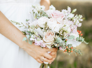 Bride holding wedding bouquet with white and pink flowers