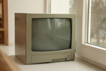 Old tv set on white windowsill indoors