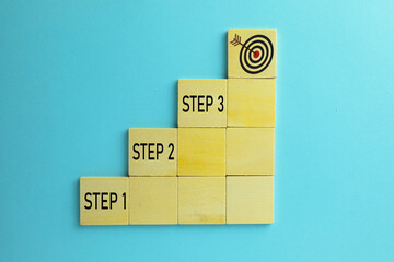 Wooden block stacking as step stair with step1,2,3 and archery target over blue sky background use...