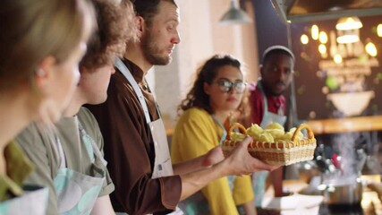 Professional chef telling about pasta to young multiethnic students during cooking master class in kitchen