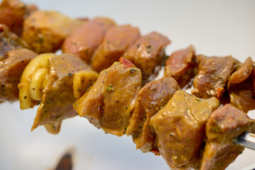 marinated meat skewered on two skewers on a white plate
