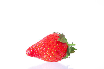 Red ripe strawberries shot against a white background with balsamic vinegar, chocolate being drizzled over