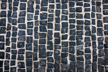 Paving stones, the road is paved with black square tiles. Stone texture, grunge background.