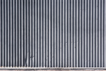 Metallic industrial background with pinstripes. The metal cover is painted with gray paint. Metal fence, strip, line, corrugated sheet, corrugated metal