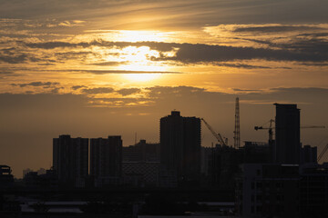 Fototapeta na wymiar sunset over the city and hight crane work on hight building