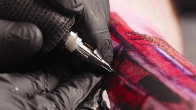 Doing a tattoo - tattooing the letters over red sketch