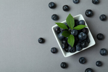 Fresh blueberry with leaves on gray background