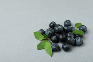 Fresh blueberry with leaves on gray background