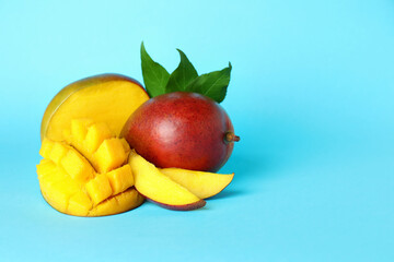 Tasty ripe mango fruit on blue background