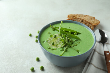 Concept of tasty eating with pea soup on white textured table