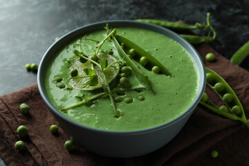Concept of tasty eating with pea soup on black smokey table