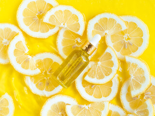 Glass essential oil, serum bottle on summer background with yellow lemon slice in water with ripples