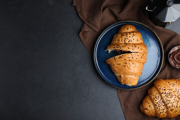 Flat lay composition with tasty croissants on black table. Space for text