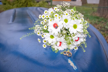 Wedding bouquet with rings on the bottom of a blue boat.