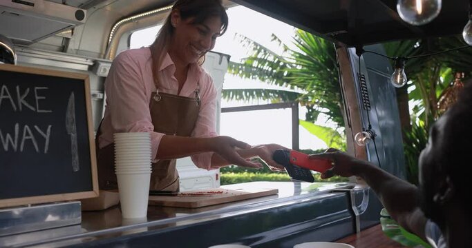 Latin woman serving takeaway food with eco paper boxes inside food truck - Small business owner concept