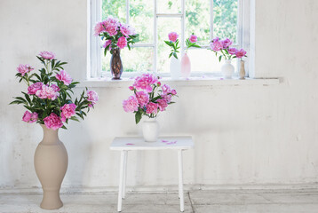 pink peony in vase on grunge white interior