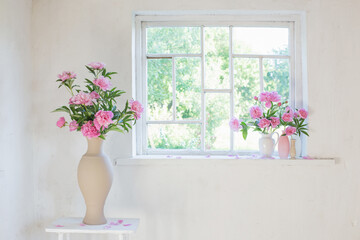 pink peony in vase on grunge white interior