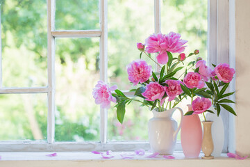 pink peony in vase on grunge white interior
