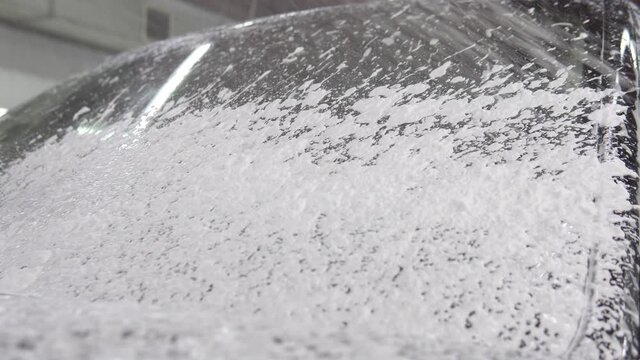 Car wash. Pouring foam on windshield.