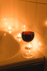 Glass of wine and a bath with candles