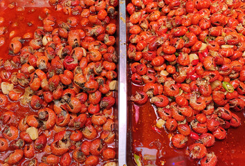 red cooked fresh crayfish in the red oil in the pan for sale in the night market in Rizhao
