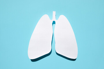 Paper silhouette of anatomical lungs on a blue background. Healthy breathing concept.