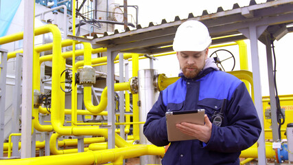 Man inspector using digital tablet at gas station