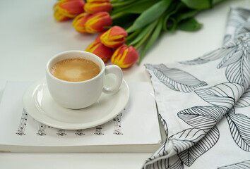 Red tulip on the white background with coffee. Flamed tulip, red and yellow. 