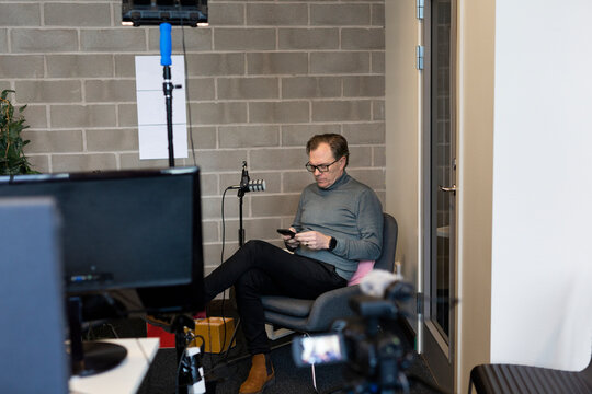 Man using cell phone in front of microphone
