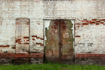 Old metal doors. Flaking paint and rust on gates of abandoned building.