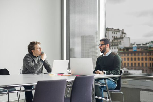 Coworkers talking in board room
