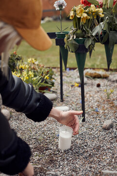 Woman lighting candle at cemetery