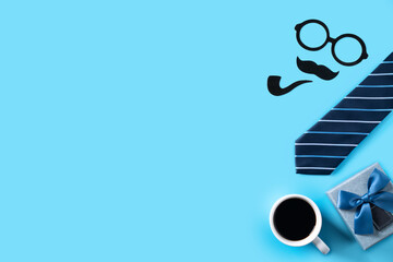 Father's day gift design concept. Top view of paper decoration with necktie and gift on blue table background.