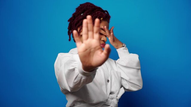 Dissatisfied afro american woman showing her refusal, denies something against blue background