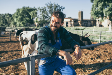 Young farmer is working on farm with dairy cows. Agriculture industry, farming.