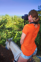 travel photographer girl takes a picture from a horse on the coast of the Atlantic Ocean 
