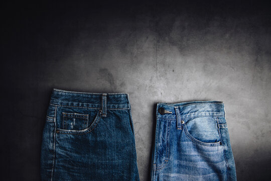 Jeans Pant Lay On Cement Floor. Fashion, Clothes For Any Gender, Classic Wearing For Diversity. Top View, Dark Tone