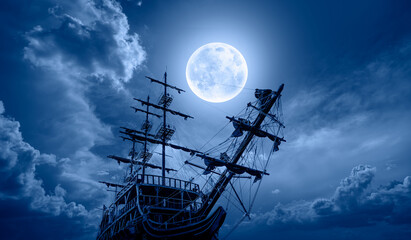 Sailing old ship in storm sea - Night sky with moon in the clouds 