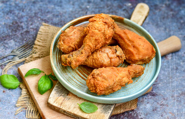 
 Crispy  deep fried home made    chicken   legs Breaded  with  almond flour chicken  breast fillets  with chilly peppers and fresh   basil on wooden rustic background. Ketogenic diet food