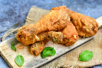 
 Crispy  deep fried home made    chicken   legs Breaded  with  almond flour chicken  breast fillets  with chilly peppers and fresh   basil on wooden rustic background. Ketogenic diet food