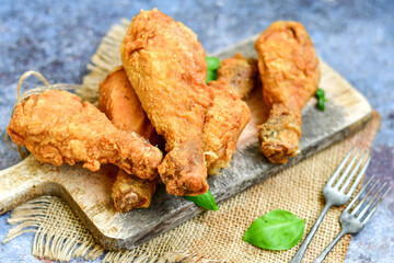 
 Crispy  deep fried home made    chicken   legs Breaded  with  almond flour chicken  breast fillets  with chilly peppers and fresh   basil on wooden rustic background. Ketogenic diet food
