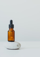 Brown glass bottle with serum, essential oil or other cosmetic product. Natural organic cosmetic packaging, skin care concept.