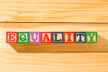 Spectacular wooden cubes with the word EQUALITY on a wooden surface.