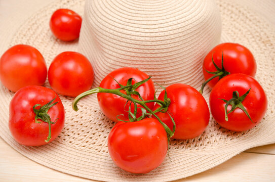 original summer image of a straw hat and ripe tomatoes close-up