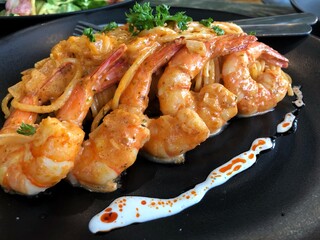 spicy prawn spaghetti on black plate served in restaurant for dinner