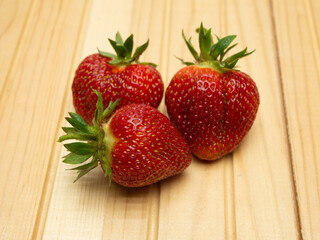 Freshly picked strawberries on wooden background. Healthy food and nutrition.