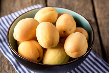 Delicious Ripe Apricots in Bowl on the Linen Napkin Old Wooden Background Above