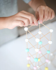 STEM education, Close up hands, child learning making 3D geometric shapes, Building Structure.